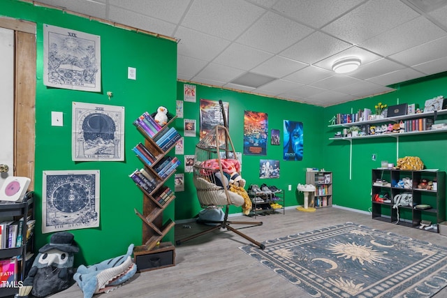 rec room with wood-type flooring and a paneled ceiling