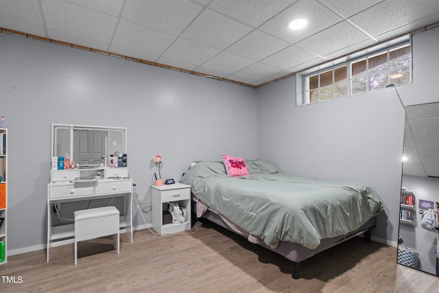 bedroom featuring light wood-type flooring and a paneled ceiling