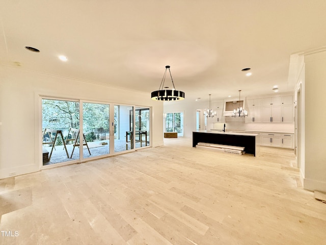 interior space featuring ornamental molding, sink, a notable chandelier, and light hardwood / wood-style flooring