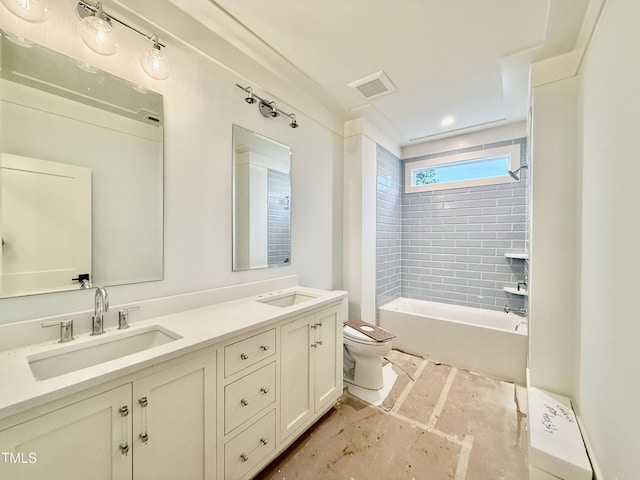 full bathroom with tiled shower / bath, vanity, and toilet