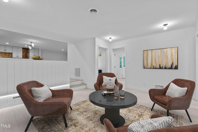 sitting room with light hardwood / wood-style flooring and ornamental molding