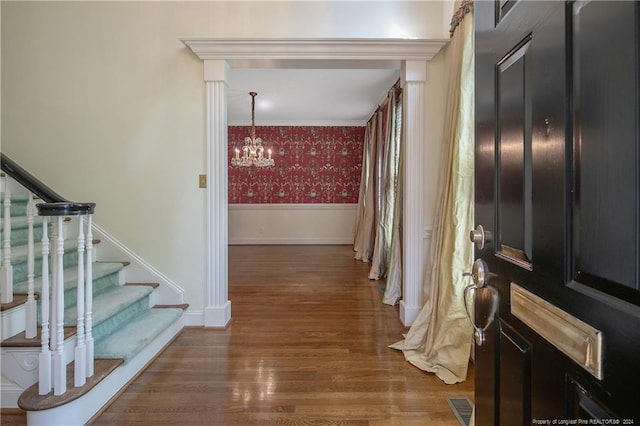 interior space with an inviting chandelier, dark wood-type flooring, and crown molding