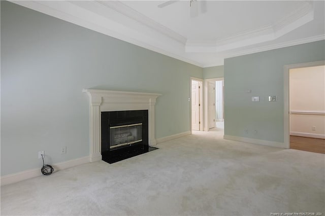 unfurnished living room featuring a raised ceiling, ceiling fan, light colored carpet, and crown molding