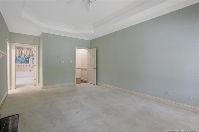 unfurnished bedroom with crown molding, a tray ceiling, ceiling fan, and light carpet