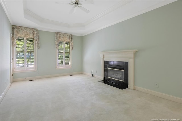 unfurnished living room with ornamental molding, a tray ceiling, light carpet, and ceiling fan