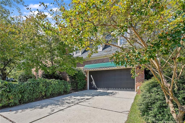 view of property hidden behind natural elements with a garage