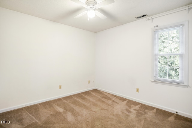 carpeted spare room featuring ceiling fan