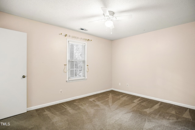 carpeted spare room featuring ceiling fan and a textured ceiling