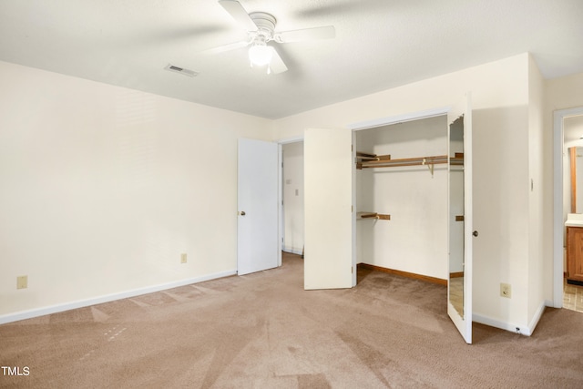 unfurnished bedroom featuring ceiling fan, light colored carpet, and a closet