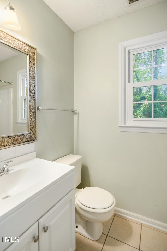 bathroom featuring tile patterned flooring, a textured ceiling, vanity, and toilet