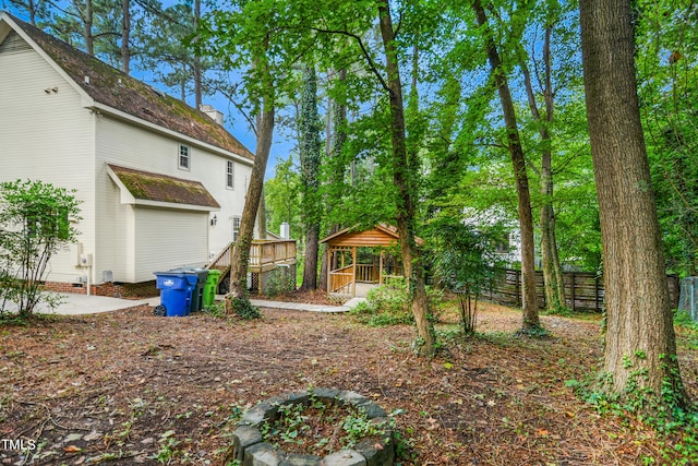 view of yard featuring a deck and a fire pit