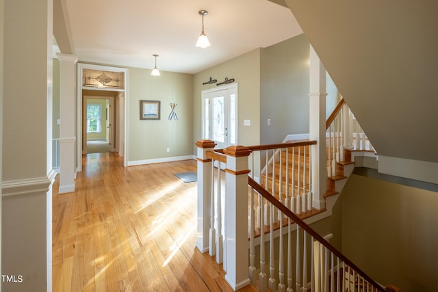 corridor featuring light hardwood / wood-style floors and decorative columns