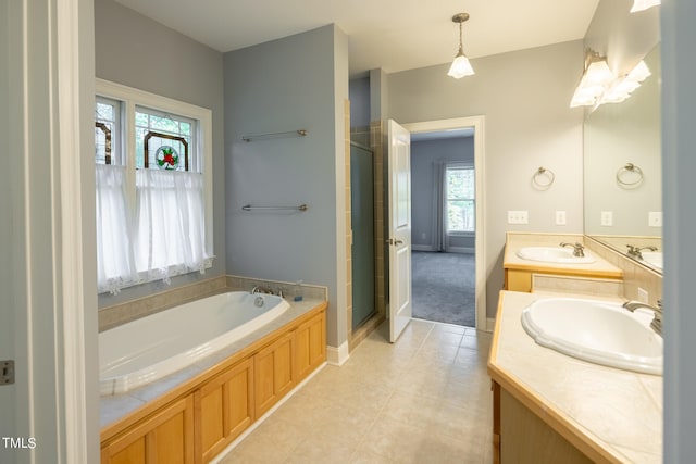 bathroom with vanity, shower with separate bathtub, tile patterned flooring, and a healthy amount of sunlight