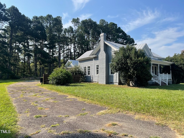 view of side of property featuring central air condition unit, a porch, and a yard