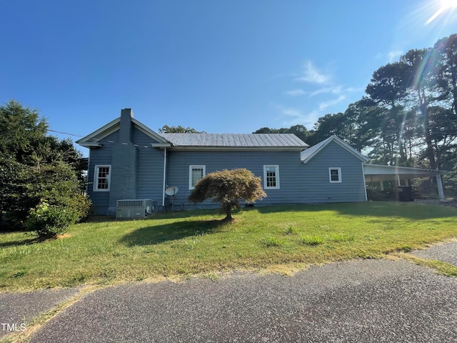 ranch-style house featuring a front lawn and central AC