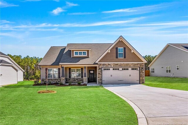 craftsman house with driveway, a front lawn, roof with shingles, and stone siding