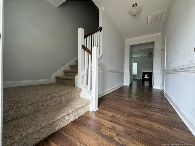 staircase with ceiling fan, hardwood / wood-style flooring, and ornamental molding