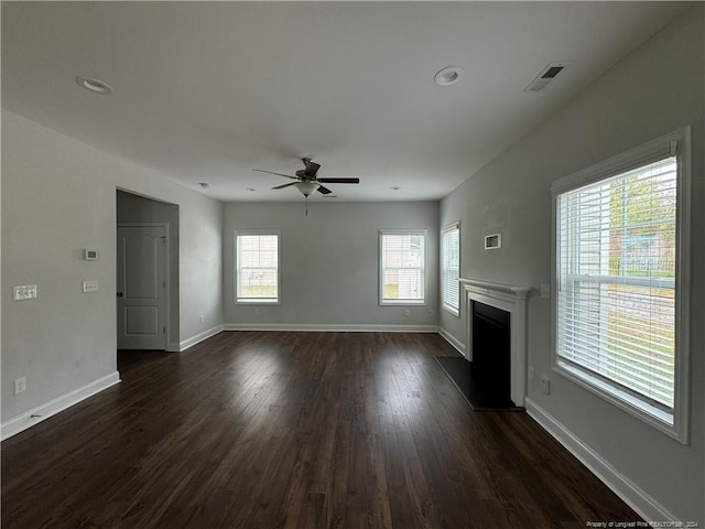 unfurnished living room featuring ceiling fan and dark wood-type flooring