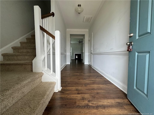 foyer featuring crown molding, dark hardwood / wood-style flooring, and ceiling fan