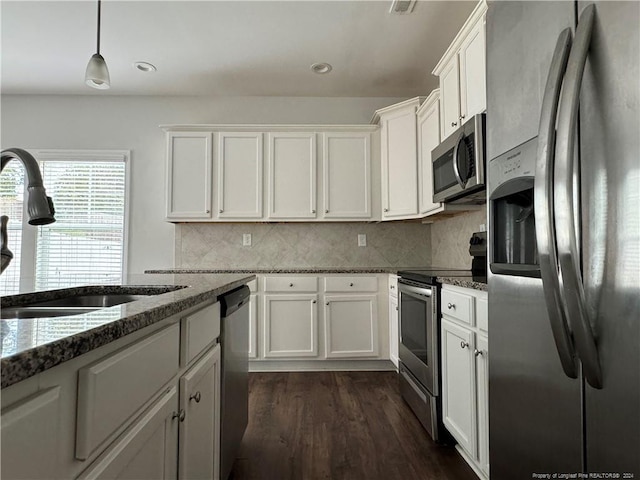 kitchen with white cabinets, appliances with stainless steel finishes, and dark wood-type flooring