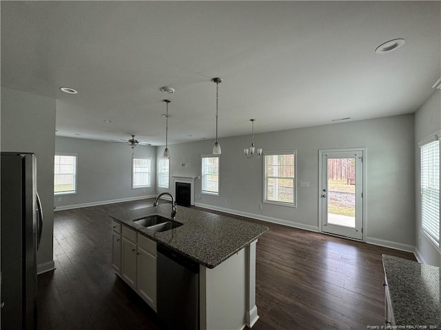 kitchen with dark hardwood / wood-style flooring, an island with sink, appliances with stainless steel finishes, and sink