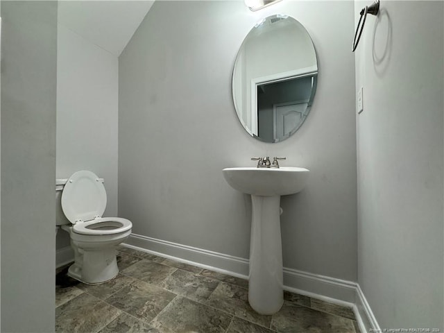 bathroom with vaulted ceiling and toilet