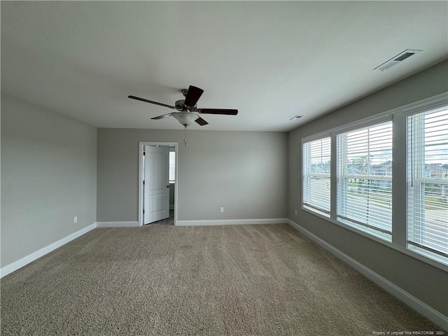 carpeted spare room featuring ceiling fan