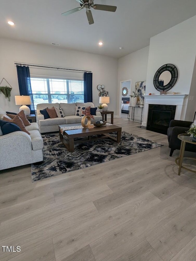 living room with ceiling fan and light hardwood / wood-style flooring