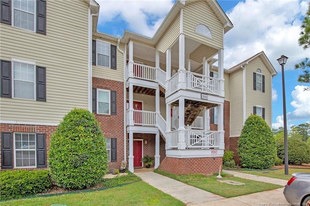 view of front facade with a front yard and a balcony