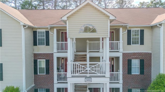exterior space with brick siding and a balcony