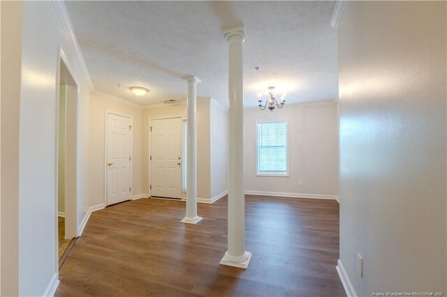 entryway featuring a textured ceiling, ornamental molding, baseboards, and dark wood-type flooring