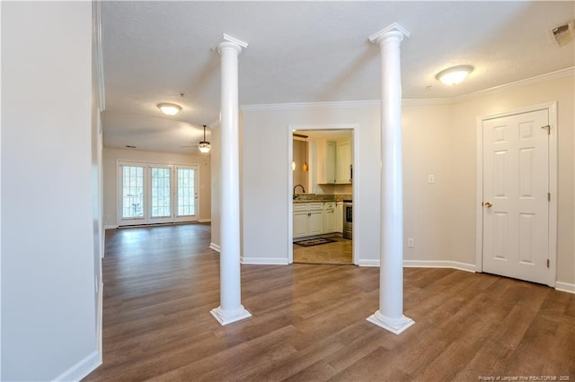 unfurnished living room with baseboards, ornamental molding, a ceiling fan, and dark wood-style flooring