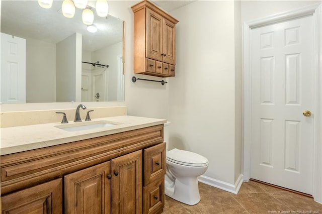 bathroom with vanity, toilet, baseboards, walk in shower, and tile patterned floors