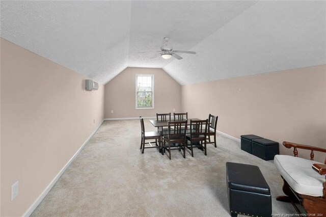 carpeted dining room with a textured ceiling, vaulted ceiling, ceiling fan, and a wall mounted AC