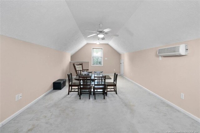 dining space with vaulted ceiling, ceiling fan, light colored carpet, and a wall mounted AC