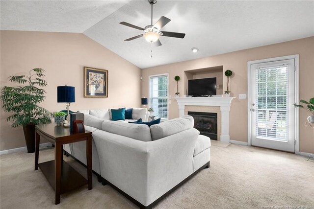 living room featuring vaulted ceiling, ceiling fan, and light colored carpet