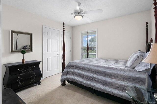 carpeted bedroom featuring ceiling fan, a textured ceiling, and a closet