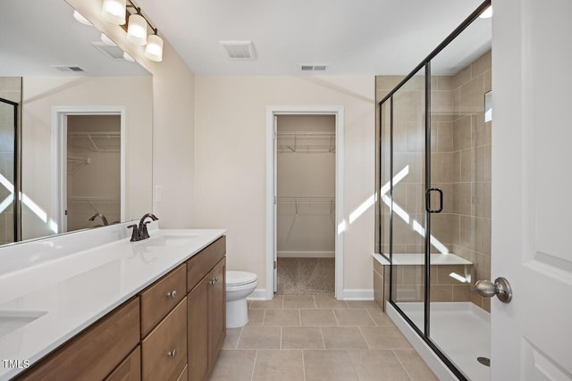 bathroom featuring vanity, walk in shower, tile patterned floors, and toilet