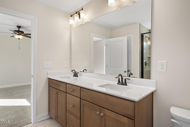 bathroom with tile patterned floors, a shower with door, vanity, toilet, and ceiling fan