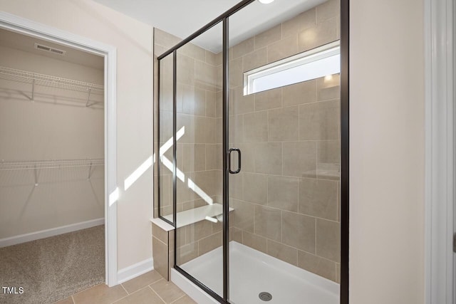 bathroom featuring a shower with door and tile patterned flooring