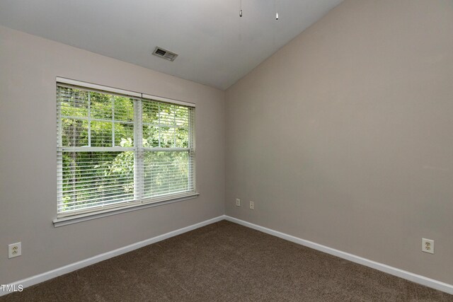 carpeted empty room with vaulted ceiling