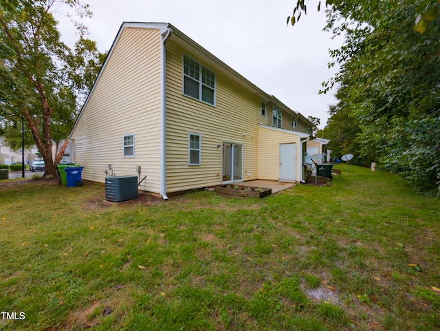 back of house featuring a patio, central AC unit, and a yard