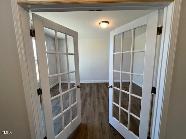 doorway with baseboards, dark wood finished floors, and french doors