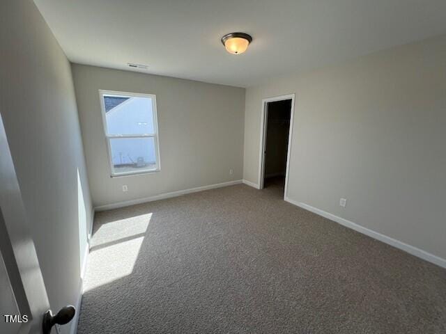 carpeted empty room with visible vents and baseboards