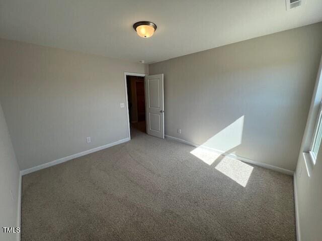 unfurnished room with light carpet, visible vents, and baseboards