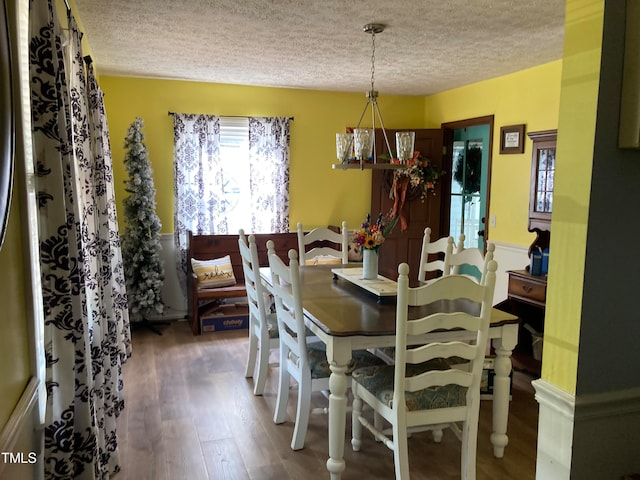 dining space featuring a textured ceiling and hardwood / wood-style floors