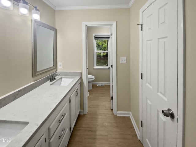 bathroom featuring crown molding, wood-type flooring, vanity, and toilet