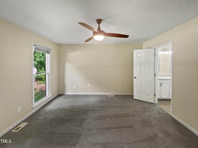 carpeted spare room featuring ceiling fan