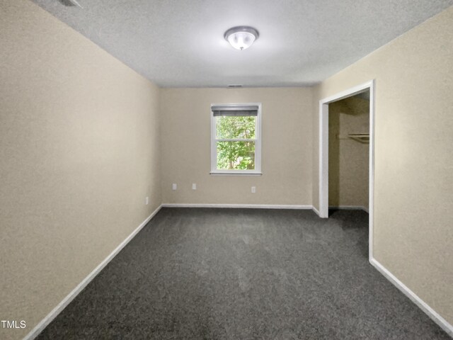 carpeted spare room with a textured ceiling