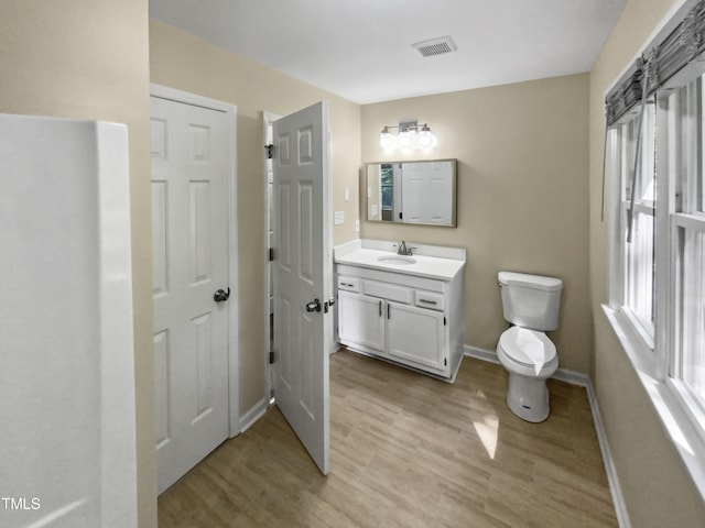 bathroom with hardwood / wood-style flooring, vanity, and toilet